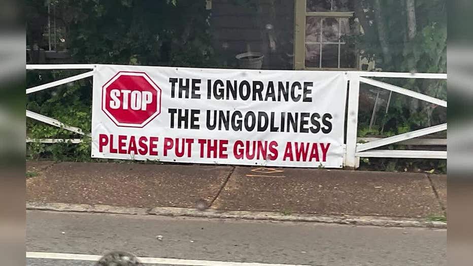 A sign asks people to "Please put the guns away" after a deadly shooting.