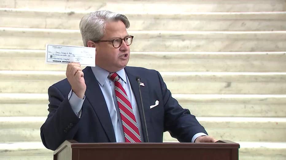 Gabe Sterling, the Georgia Secretary of State’s COO, holds up the restitution check made by former Trump attorney Sidney Powell, calling it vindication for election integrity in the state.