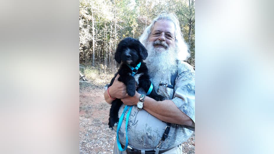 Jonathan Byrd, who plays Santa Claus for several Athens, Georgia, organizations, poses in plain clothes with his dog. He had a long white beard and long hair that make him look a lot like Santa even without the costume.