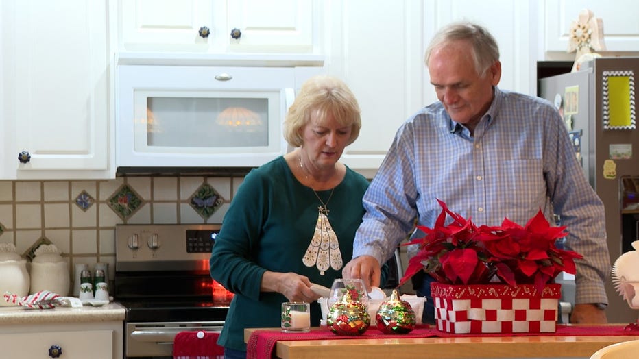 Couple in their late sixties bake cookies in their kitchen.