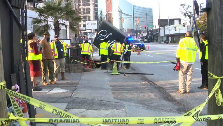 Atlanta Watershed Management crews shut off a water main break which opened up a sinkhole which swallowed a section of the sidewalk and a restaurant sign along Peachtree Street in Buckhead on Feb. 26, 2024.
