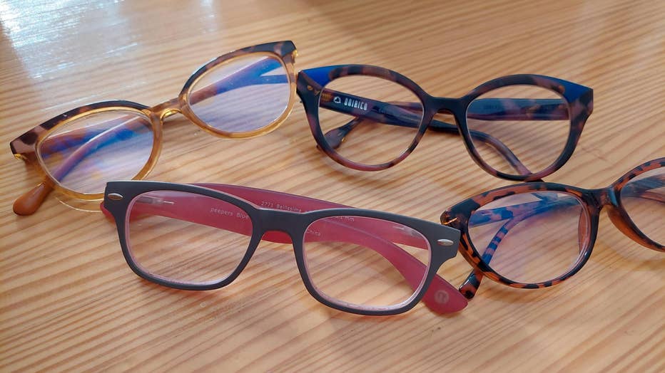 Four pairs of eyeglasses sit on a table