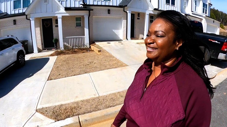 An African American woman smiles as she walks outside.
