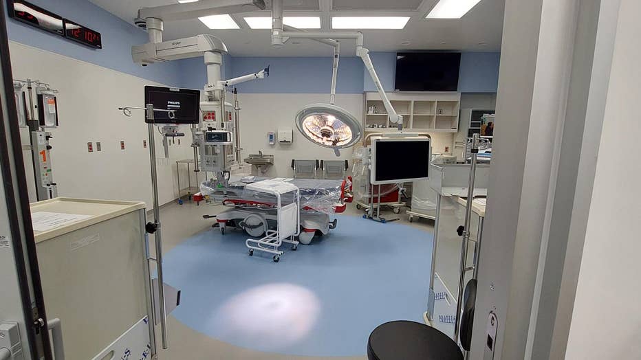 A large new trauma treatment room with a gurney surrounded by medical equipment and lights