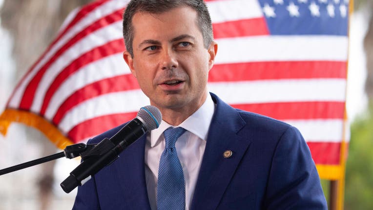 Pete Buttigieg, US secretary of transportation, stands at a podium in Long Beach, California in front of the American flag.