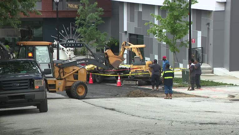 Construction vehicles appear to repave a road at the scene of a water main break in the Buckhead neighborhood of Atlanta.