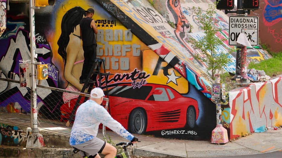 Artist SparkyZ, whose real name is Zack White, shows off his latest mural paying homage to the Grand Theft Auto series and the city of Atlanta at the Krog Street Tunnel on July 9, 2024. 