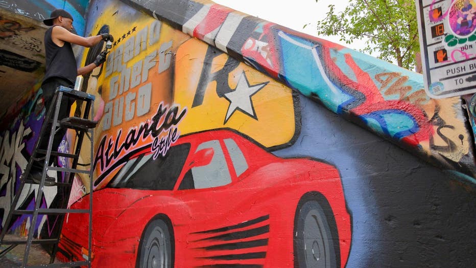 Artist SparkyZ, whose real name is Zack White, shows off his latest mural paying homage to the Grand Theft Auto series and the city of Atlanta at the Krog Street Tunnel on July 9, 2024.