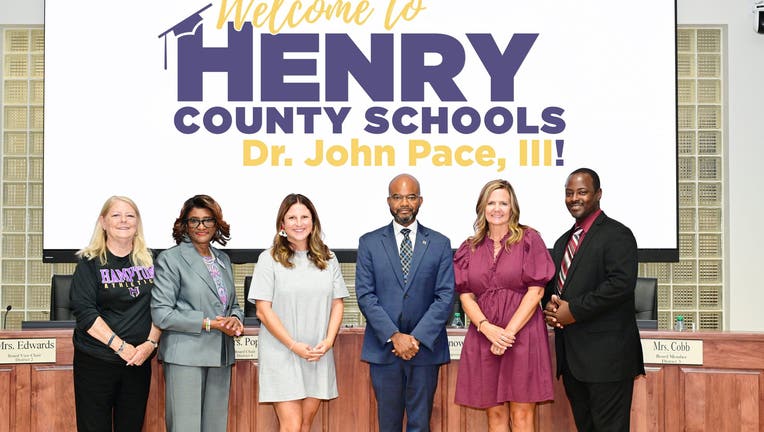 Dr. John Pace III stans with the Henry County Board of Education after unanimously being confirmed as the new school superintendent on Aug. 6, 2024. 