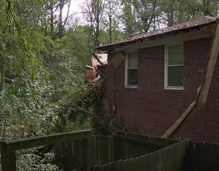 A massive tree falls on a home along Camelot Circle in Tucker on Sept. 27, 2024.