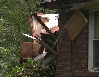 A massive tree falls on a home along Camelot Circle in Tucker on Sept. 27, 2024.