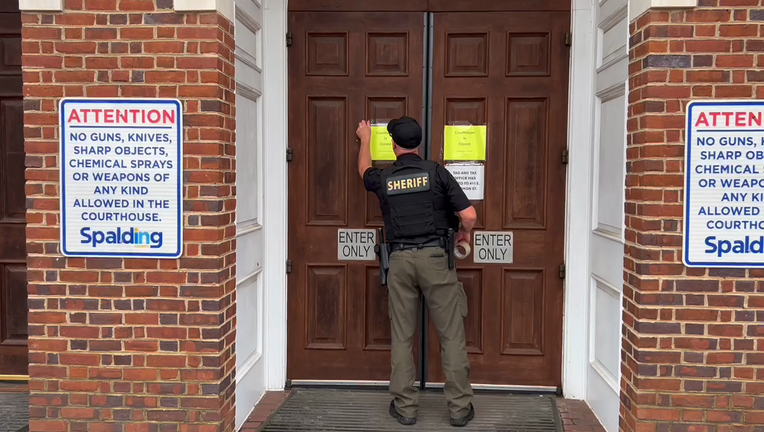 Spalding County deputies tape a sign on the courthouse after a shooting on Sept. 13, 2024.