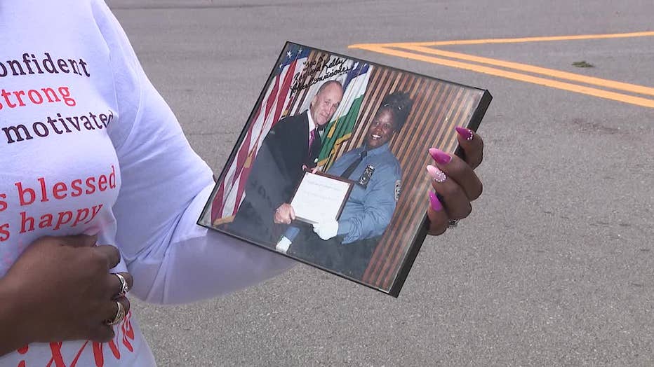 Former NYPD officer Deborah Darrisaw shows a picture of her with the former New York City Police Commissioner. 