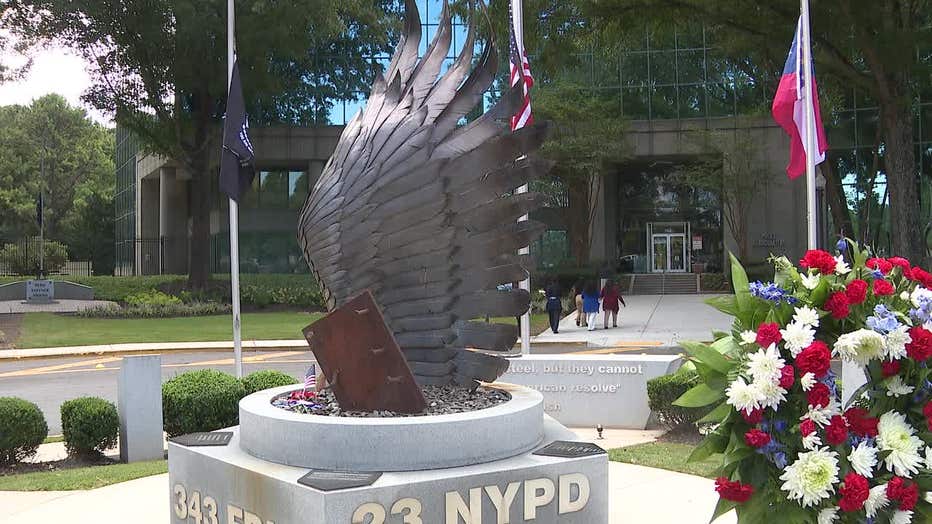 Former NYPD officer Deborah Darrisaw, accompanied by her children, visits the 9/11 memorial in DeKalb County on Sept. 11, 2024.