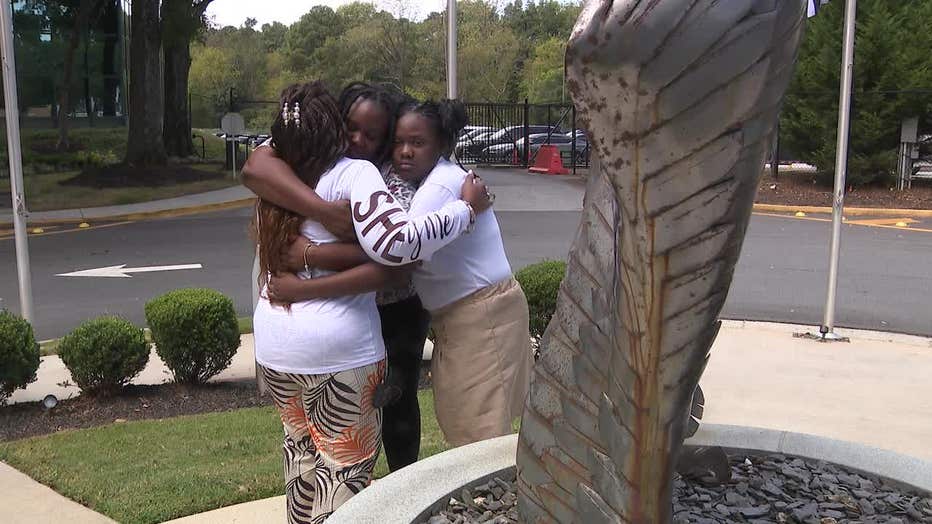 Former NYPD officer Deborah Darrisaw, accompanied by her children, visits the 9/11 memorial in DeKalb County on Sept. 11, 2024.