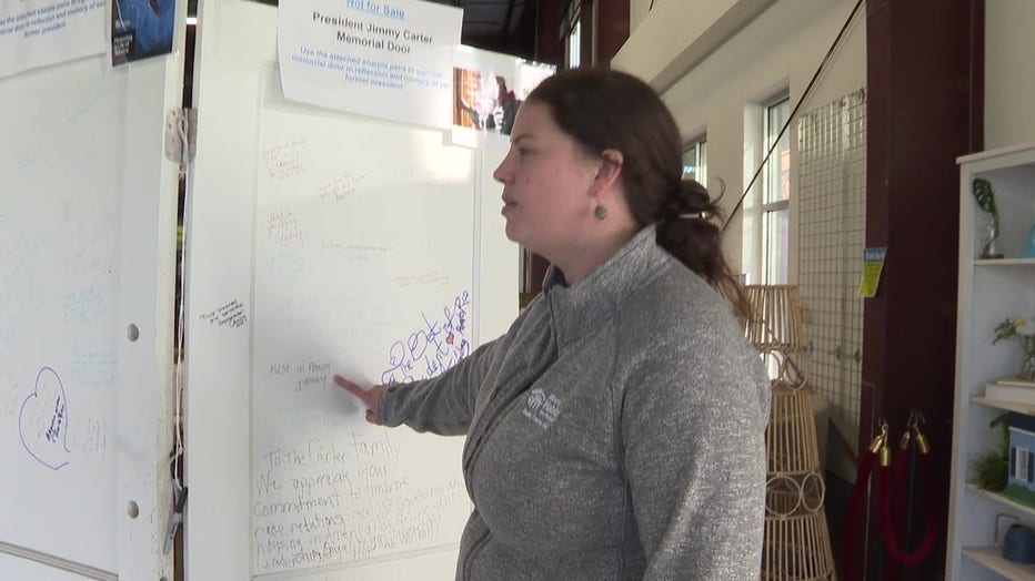 Megan McCabe, director of the Atlanta Habitat for Humanity ReStore, points out a tribute to the late President Jimmy Carter on a memorial door on Jan. 6, 2025.