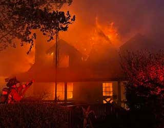 Firefighters in Greene County work to battle a log cabin fire on May 17, 2025.