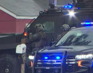 A SWAT team stands outside in the rain during a standoff along LaVista Road at Henderson Road in Tucker on May 29, 2025.
