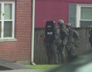 A SWAT team stands outside in the rain during a standoff along LaVista Road at Henderson Road in Tucker on May 29, 2025.