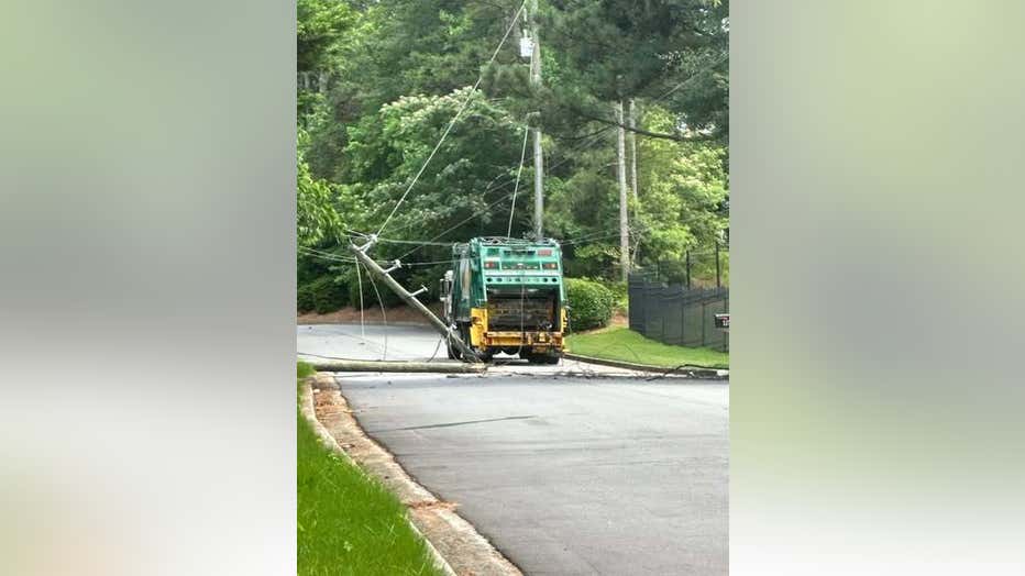 Power lines fall on a garbage truck along Castleberry Drive at Chatham Road in Gwinnett County on June 10, 2025.