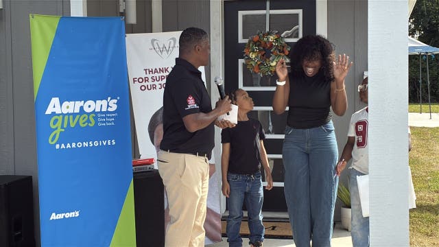 Former Falcon Warrick Dunn helps two families furnish new homes