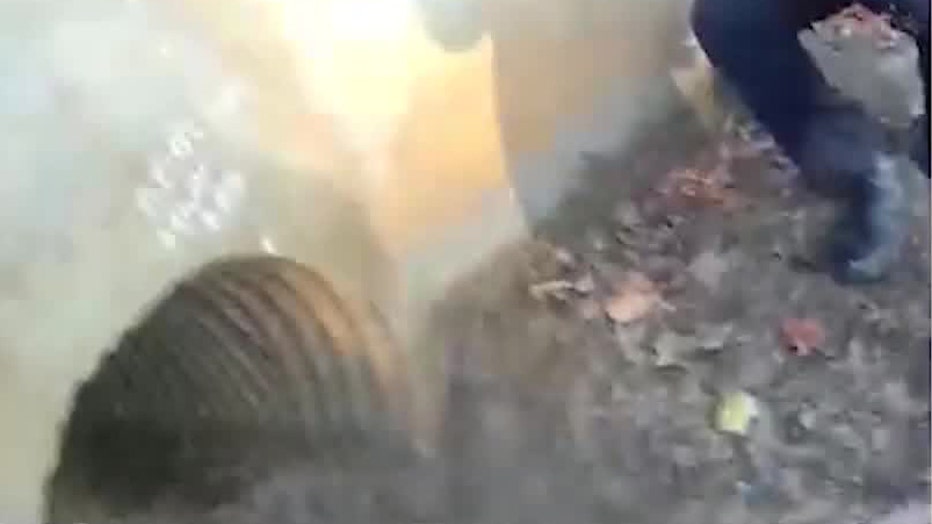 Gwinnett officers look into a storm drain at Peachtree Ridge Park while searching for a missing five-year-old boy with autism on November 15, 2025.