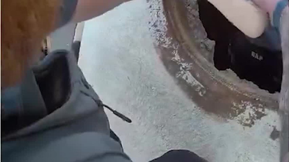 Officers lift the five-year-old boy from a manhole after Officer Steven Nunez located him several hundred feet inside a drain at Peachtree Ridge Park on November 15, 2025.