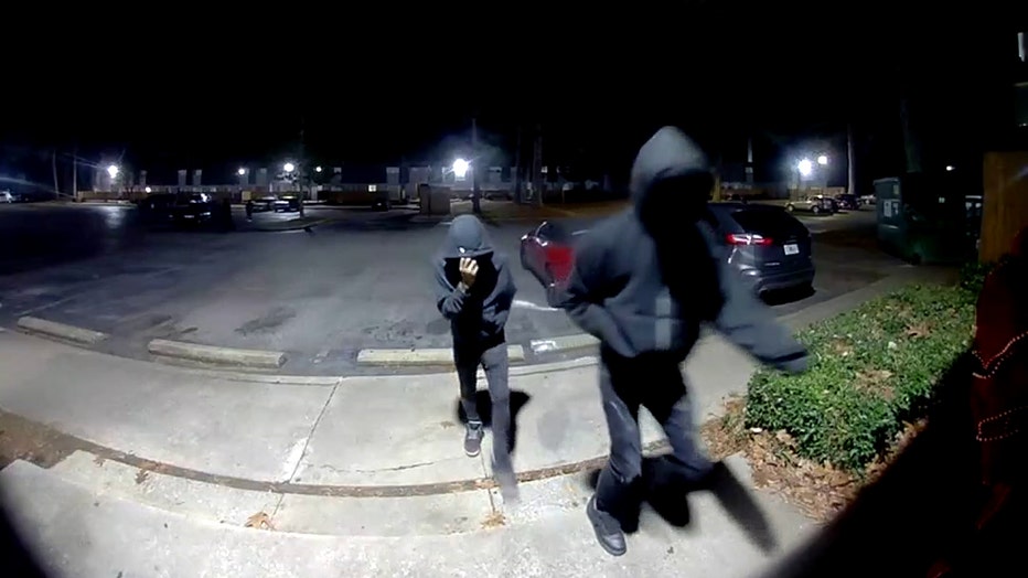 Two hooded figures walk toward an apartment door moments before a 9-year-old boy and his mother were shot inside their southwest Atlanta unit. The footage was recorded at a complex on Continental Colony Parkway on December 10, 2025.