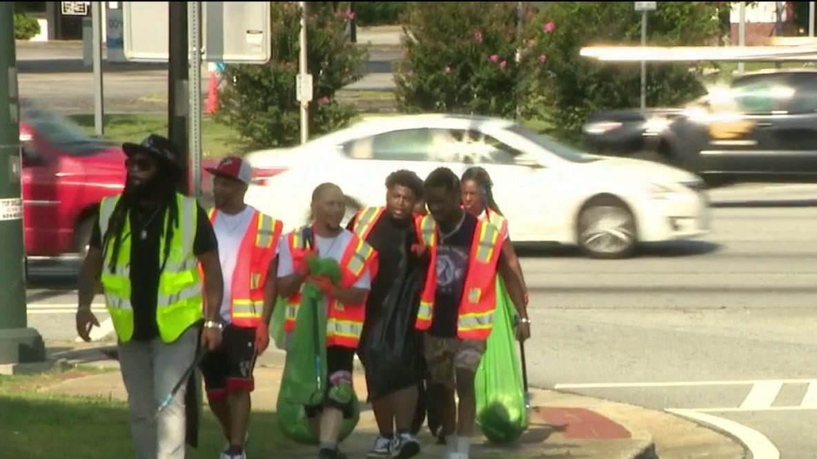 Volunteers clean up Old National Highway ahead of block party