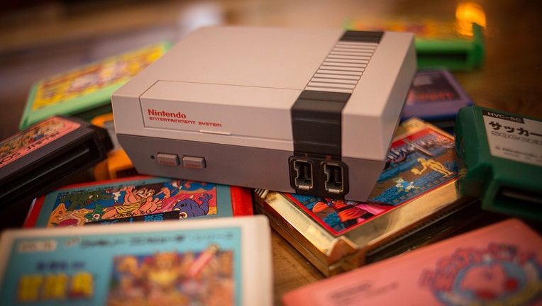 FILE: A Nintendo Classic Mini 'Nintendo Entertainment System' video game console first generation, popular in the 1980's, seen with a pile of game cartridges. 