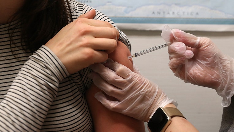A woman receives a flu shot. 