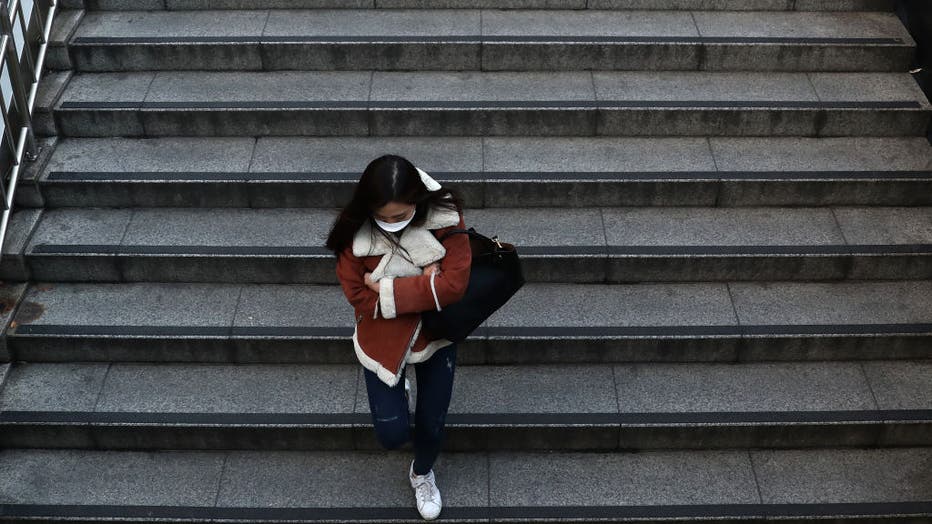 A woman wearing a mask to prevent the coronavirus (COVID-19) walks along the street on Feb. 22, 2020 in Seoul, South Korea.