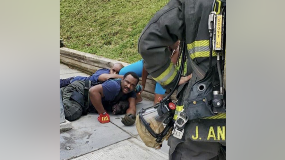 DC firefighters hold dogs down to protect residents while fighting a fire in Southeast