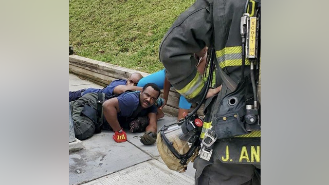 DC firefighters hold dogs down to protect residents while fighting a fire in Southeast