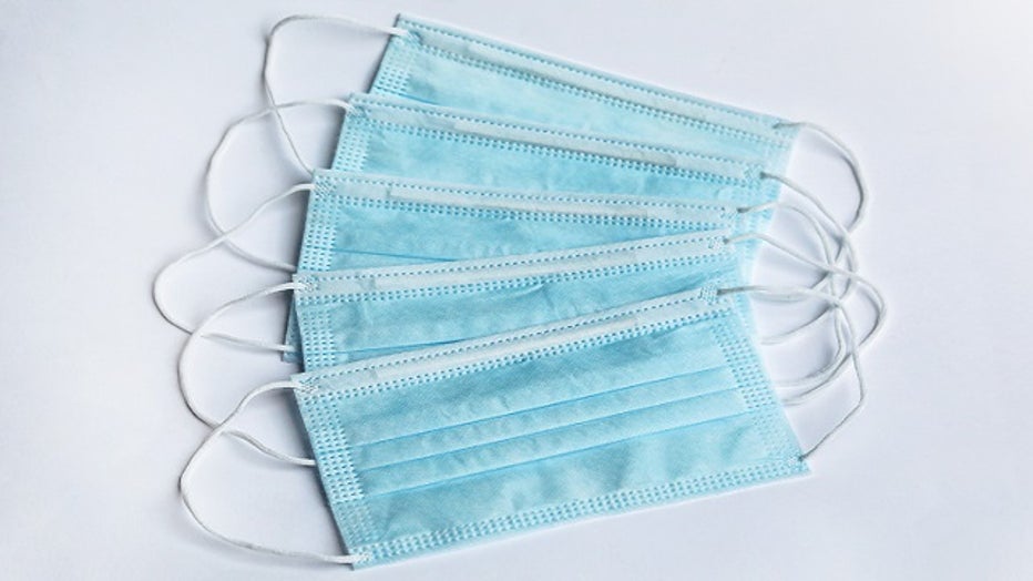 FILE - Surgical masks on a white surface stock photo.