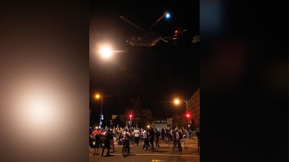 Helicopter flies over protesters