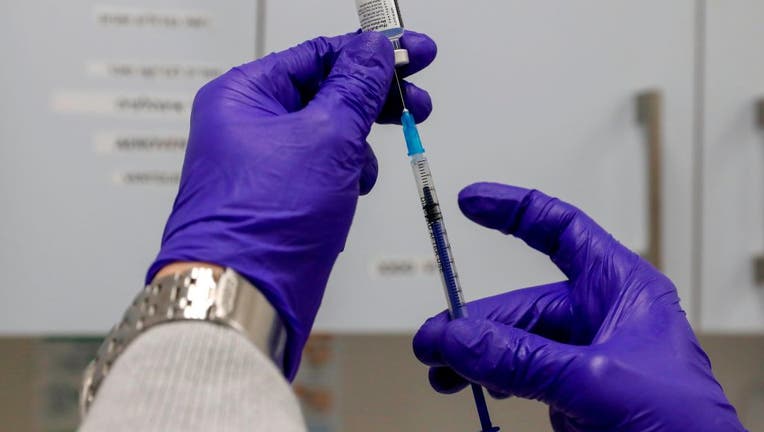 FILE - A health worker prepares a dose of the Pfizer-BioNtech COVID-19 vaccine at the Clalit Health Services in the Palestinian neighbourhood of Beit Hanina, in the Israeli-annexed east Jerusalem on March 2, 2021. (Photo by AHMAD GHARABLI / AFP)