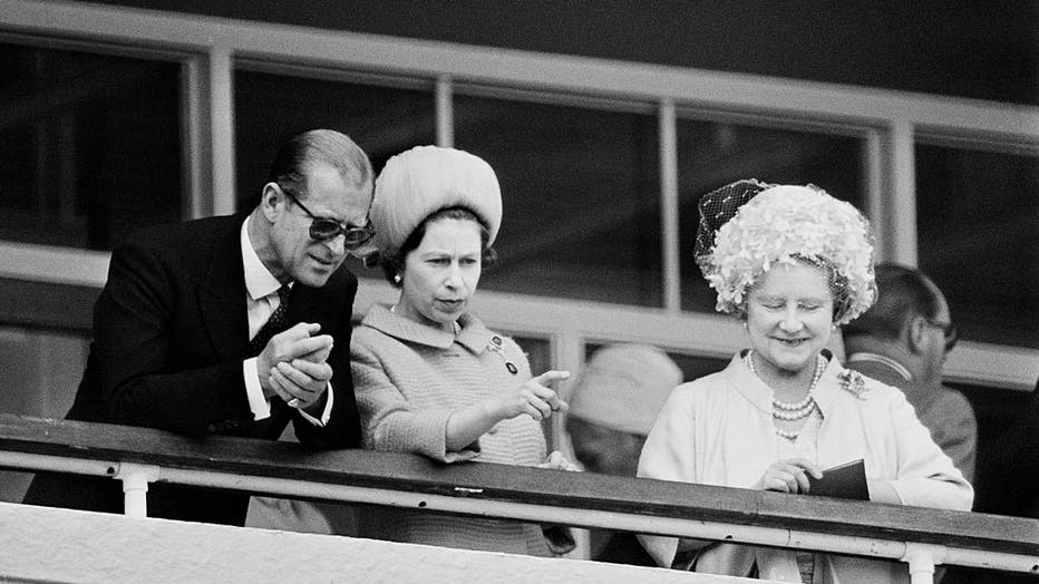 FILE - Prince Philip, Duke of Edinburgh, Queen Elizabeth II, and Queen Elizabeth, the Queen Mother watch the racing on Derby day at Epsom Downs race course in June 1967. (Photo by Victor Blackman/Express/Hulton Archive/Getty Images)
