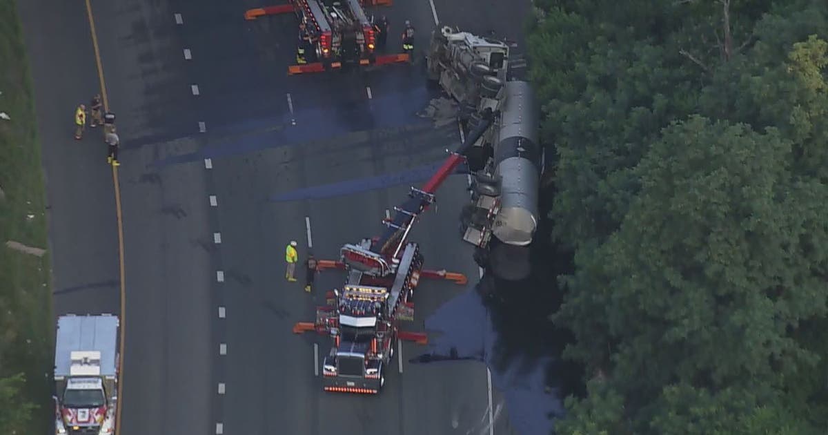 Overturned tractor trailer leaking liquid asphalt causes major delays ...