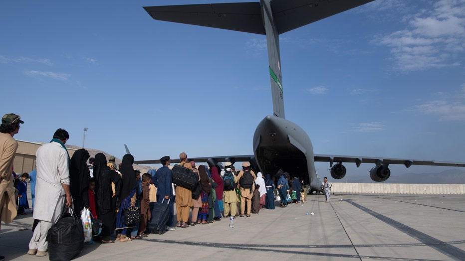 People board a U.S. Air Force C-17 Globemaster III at Hamid Karzai International Airport in Kabul, Afghanistan.
