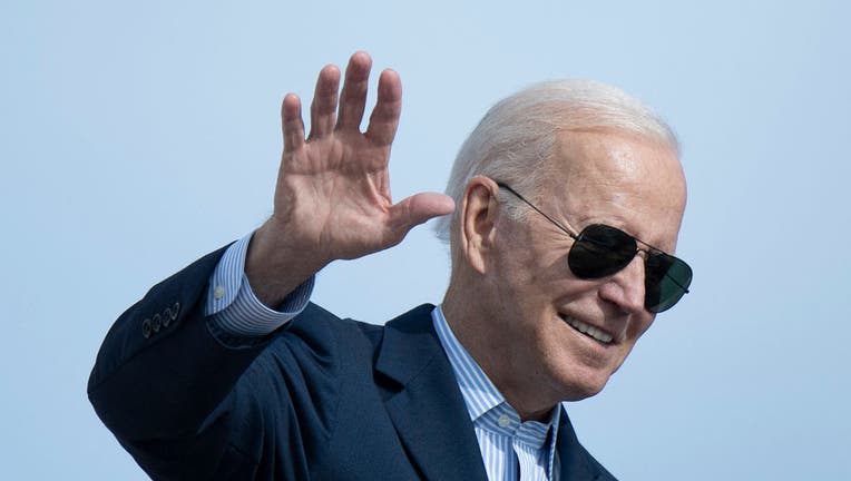 US President Joe Biden waves as he boards Air Force One at Andrews Air Force Base before departing for Italy and the United Kingdom on Oct. 28, 2021, at Joint Base Andrews, Maryland. (Photo by BRENDAN SMIALOWSKI/AFP via Getty Images)