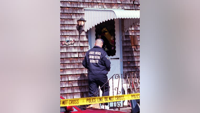 (3/24/01-New Bedford, MA.--CRIME SCENE- State police crime scene specialist heads into the side entrance of the home of Rose Marie Moniz, who was found murdered there yesterday. (032401crimescene--Staff Photo by Renee DeKona- saved in photo 3/sun)