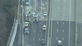 Crane called to remove overturned vehicle that flipped over concrete barrier in Woodbridge