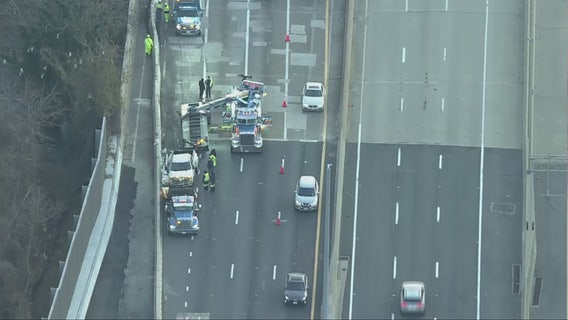 Crane called to remove overturned vehicle that flipped over concrete barrier in Woodbridge