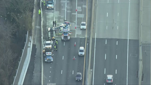 Crane called to remove overturned vehicle that flipped over concrete barrier in Woodbridge