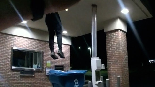 Watch: Bank burglar lands in recycling bin as police wait with guns drawn