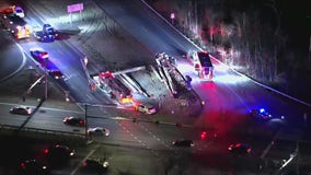 Overturned tractor-trailer spills logs onto roadway in Crofton