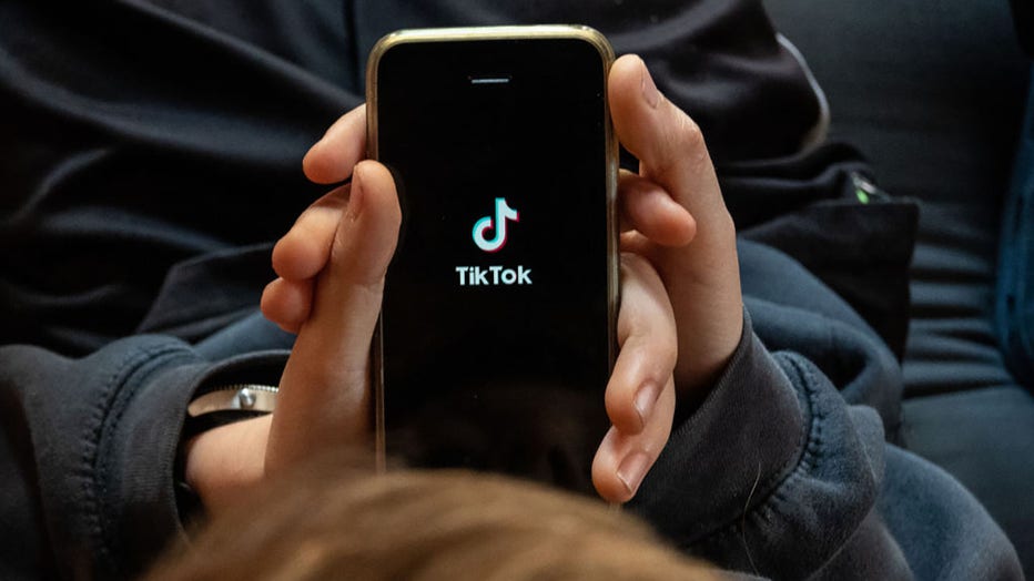 FILE - In this photo illustration, a boy looks at the TikTok app on a smartphone screen. (Photo by Matt Cardy/Getty Images)