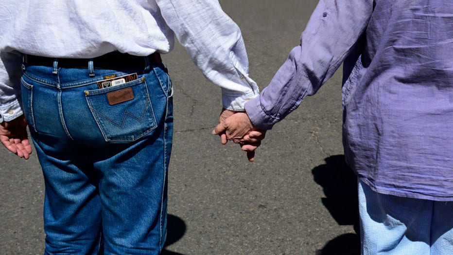 FILE - An elderly couple walks hand-in-hand down a street in Santa Fe, New Mexico. (Photo by Robert Alexander/Getty Images)