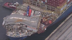 Baltimore Key Bridge collapse: Section of roadway that fell remains unbroken across container ship